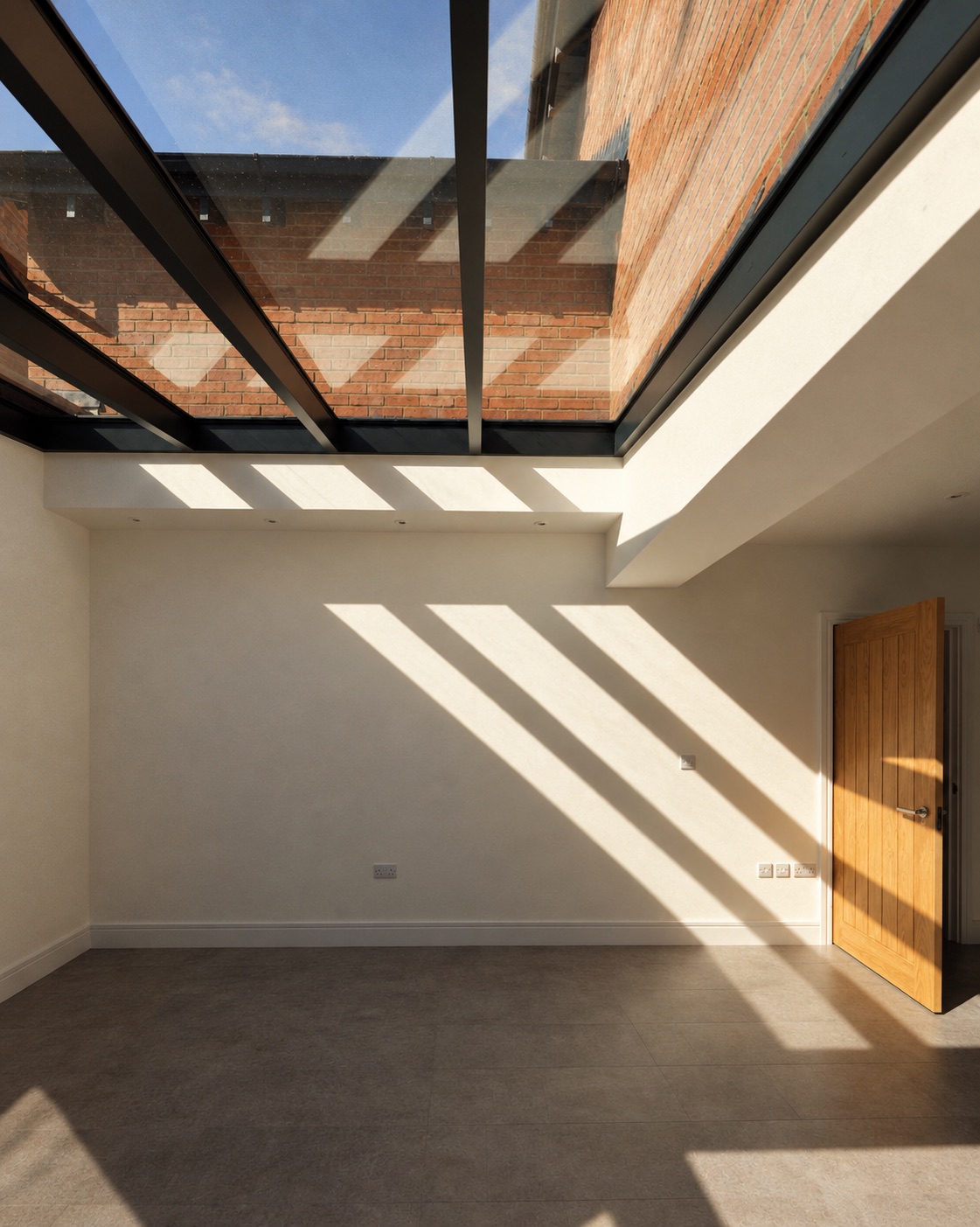 Sunlit skylight casting strong geometric shadows across a minimalist interior